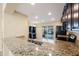 Open kitchen with granite countertops, stainless steel appliances, and access to outdoor patio at 12523 Longstone Ct, New Port Richey, FL 34655