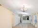 Open-concept living room with tile flooring, large windows, neutral paint, and stylish chandelier lighting at 12523 Longstone Ct, New Port Richey, FL 34655