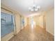 Bright living room with tile flooring, modern chandelier, and natural light from large windows at 12523 Longstone Ct, New Port Richey, FL 34655