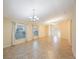 Spacious living area with ceramic tile floors, neutral walls, large windows, and decorative chandelier lighting at 12523 Longstone Ct, New Port Richey, FL 34655
