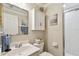 Well-lit bathroom featuring a vanity, storage cabinet and a glass door shower at 156 117Th Ave, Treasure Island, FL 33706