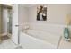 Bathroom with soaking tub, glass-enclosed shower, and decorative artwork at 156 117Th Ave, Treasure Island, FL 33706