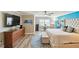 Bright bedroom features a large bed, accent wall, wood floors, and a ceiling fan at 156 117Th Ave, Treasure Island, FL 33706