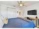 Comfortable bedroom includes a ceiling fan, TV, desk, and closet at 156 117Th Ave, Treasure Island, FL 33706