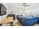 Comfortable bedroom features a ceiling fan, a desk, and a TV at 156 117Th Ave, Treasure Island, FL 33706