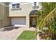 Charming home exterior with a well-manicured lawn, two-car garage, and covered entryway at 156 117Th Ave, Treasure Island, FL 33706