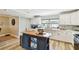 This kitchen is light and bright, with a stainless steel sink and white cabinets and custom island at 156 117Th Ave, Treasure Island, FL 33706