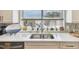 Stainless steel sink under a window with custom backsplash, and white cabinets offers a clean modern look at 156 117Th Ave, Treasure Island, FL 33706