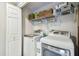 A laundry room with side-by-side washer and dryer, plus storage space and shelving is shown at 156 117Th Ave, Treasure Island, FL 33706