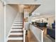 Staircase with wood and white rails overlooks the kitchen and living area, creating an open floor plan at 156 117Th Ave, Treasure Island, FL 33706