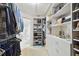 Spacious walk-in closet features custom shelving and easy access to the en-suite bathroom at 156 117Th Ave, Treasure Island, FL 33706