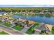 Aerial shot of single-Gathering homes surrounding a large pond with green grass and a thick tree canopy at 15909 39Th E Gln, Parrish, FL 34219