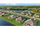 Aerial view of single-Gathering homes surrounding a large pond with manicured lawns and lush tree canopies at 15909 39Th E Gln, Parrish, FL 34219