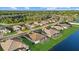 Overhead view of single-Gathering homes backing up to a large pond with green lawns and tropical trees at 15909 39Th E Gln, Parrish, FL 34219