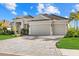 Stunning exterior showcasing a large driveway, well-manicured lawn, and beautiful landscaping at 15909 39Th E Gln, Parrish, FL 34219