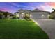 Charming home with a well-kept lawn, paver driveway, and a spacious three-car garage, captured at twilight at 15909 39Th E Gln, Parrish, FL 34219