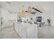 Open concept kitchen and living room feature modern lighting, white cabinets, and stainless steel appliances at 15909 39Th E Gln, Parrish, FL 34219