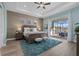 Bedroom featuring tray ceilings, a king-size bed, soft blue walls, and a sliding glass door with backyard views at 15909 39Th E Gln, Parrish, FL 34219