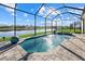 Backyard pool and spa with brick paver deck, screen enclosure, and serene water view at 15909 39Th E Gln, Parrish, FL 34219