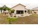 Spacious backyard with a concrete patio, desert landscaping, and an enclosed sunroom at 1603 E Del Webb Blvd, Sun City Center, FL 33573
