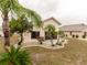 Well-maintained backyard featuring tropical landscaping and mature palm trees surrounding the home at 1603 E Del Webb Blvd, Sun City Center, FL 33573