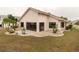 Back of house shows nice landscaping, palm trees, and a screened-in lanai at 1603 E Del Webb Blvd, Sun City Center, FL 33573