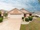 Charming single-story home with a well-manicured lawn, a two-car garage, and a beautifully patterned driveway at 1603 E Del Webb Blvd, Sun City Center, FL 33573