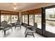 Enclosed lanai with ceiling fan and seating, surrounded by lush landscaping at 1603 E Del Webb Blvd, Sun City Center, FL 33573