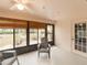 Enclosed lanai with ceiling fan and seating, surrounded by lush landscaping at 1603 E Del Webb Blvd, Sun City Center, FL 33573