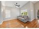 Cozy living room with wood floors, a ceiling fan, a large window, and a comfortable sofa at 1603 E Del Webb Blvd, Sun City Center, FL 33573