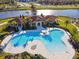 Community pool and patio in an aerial view with a lake in the background at 16614 Mosaic Oar Dr, Wimauma, FL 33598