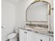 Stylish half-bathroom featuring a marble countertop, gold fixtures, and a decorative mirror at 16614 Mosaic Oar Dr, Wimauma, FL 33598
