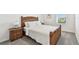 Cozy bedroom featuring a woven-style bed frame, carpeted floors, and stylish lamps at 16614 Mosaic Oar Dr, Wimauma, FL 33598