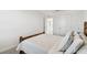 Well-lit bedroom with a woven-style bed frame, soft white bedding, and carpeted floors at 16614 Mosaic Oar Dr, Wimauma, FL 33598