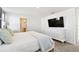 Bright bedroom featuring a white dresser with a television, and a glimpse into the attached bathroom at 16614 Mosaic Oar Dr, Wimauma, FL 33598