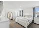 Brightly lit bedroom featuring a bed with white linen, side tables and dressers, and neutral carpeting at 16614 Mosaic Oar Dr, Wimauma, FL 33598