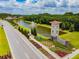 Aerial view of the community entrance featuring a fountain and lush landscaping at 16614 Mosaic Oar Dr, Wimauma, FL 33598