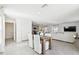 Open-concept dining area with tile floors, a wooden table, and white chairs, connecting seamlessly to the kitchen and living spaces at 16614 Mosaic Oar Dr, Wimauma, FL 33598