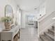 Bright foyer featuring tile floors, a stylish console table, and a staircase leading to the upper level at 16614 Mosaic Oar Dr, Wimauma, FL 33598