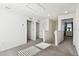 Bright hallway with carpet flooring leading to multiple bedrooms and a staircase at 16614 Mosaic Oar Dr, Wimauma, FL 33598