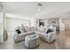 Open-concept living room with tile floors, a comfortable sectional sofa, and direct access to the kitchen and dining areas at 16614 Mosaic Oar Dr, Wimauma, FL 33598