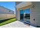 Exterior patio area featuring a sliding glass door, grass, and a privacy fence at 16614 Mosaic Oar Dr, Wimauma, FL 33598