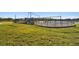Community playground with swings and play structure surrounded by lush green space and a walking path at 16614 Mosaic Oar Dr, Wimauma, FL 33598