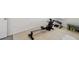 A portion of a home gym with rower, dumbbells and a weight bench on top of puzzle piece flooring at 16614 Mosaic Oar Dr, Wimauma, FL 33598