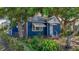 Quaint blue home with a well-manicured yard, featuring mature trees and landscaping at 1700 30Th N Ave, St Petersburg, FL 33713