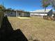 Spacious backyard with lush grass, a wooden fence, and a new deck perfect for entertaining at 1913 Park Ave, Tarpon Springs, FL 34689