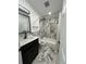 Modern bathroom featuring a marble-tiled shower and floors, dark cabinets and updated fixtures at 1913 Park Ave, Tarpon Springs, FL 34689