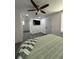 Bedroom with ceiling fan, TV, and easy access to the bathroom at 1913 Park Ave, Tarpon Springs, FL 34689
