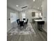 Contemporary dining area featuring a glass table with six chairs, modern lighting, and view into kitchen at 1913 Park Ave, Tarpon Springs, FL 34689