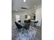 Bright dining space featuring a glass table with seating for six, modern lighting and view into the kitchen at 1913 Park Ave, Tarpon Springs, FL 34689